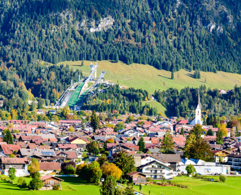 Blick auf den alpinen Kurort Oberstdorf im Allgäu im Jahr 2026 mit den schneebedeckten Gipfeln des Nebelhorns im Hintergrund. Das Bild symbolisiert die Wertstabilität des lokalen Immobilienmarktes.