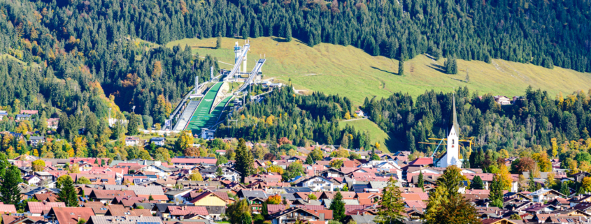Blick auf den alpinen Kurort Oberstdorf im Allgäu im Jahr 2026 mit den schneebedeckten Gipfeln des Nebelhorns im Hintergrund. Das Bild symbolisiert die Wertstabilität des lokalen Immobilienmarktes.